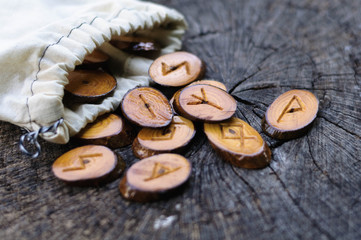 wooden runes in a bag on an old stump