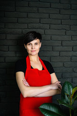 people, medicine, and healthcare concept - happy young female masseur in red apron at clinic office.Learning to cook making thumb up gesture in cooking classes small business and homemade food concept