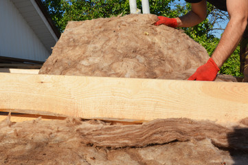 House roof renovation and repair with glass wool, fiberglass,  thermal insuation. Roofer laying...