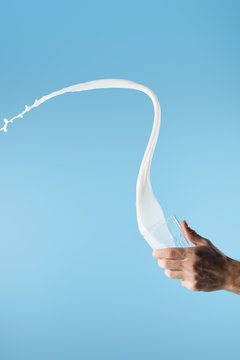 Cropped View Of Man Holding Glass With Fresh White Milk Splash Isolated On Blue