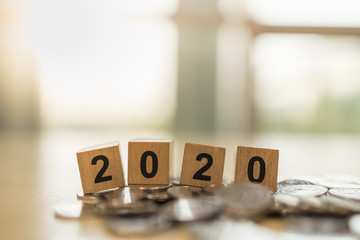 2020 New year, Business, Saving and Planning Concept. Close up of wooden number block toy on pile of coins with copy space