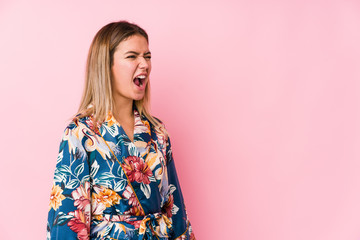 Young caucasian woman wearing pajamas shouting towards a copy space