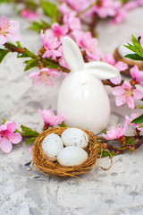 Spring conceptual photo with flowers. Flat lay blooming tree, easter eggs. The tree blooms pink and the eggs in the nest and copy space.