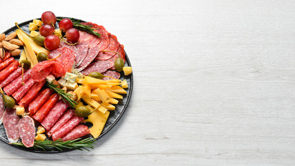 Appetizers table with italian antipasti snacks, cheese and wine in glasses. Top view. Free space for your text.