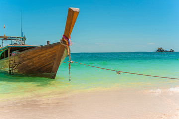 Fototapeta na wymiar Traditional Thai longtail boat moored on exotic beach.
