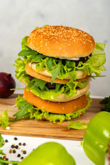 Delicious burgers prepared in a bright kitchen on a wooden table. Close-up.
