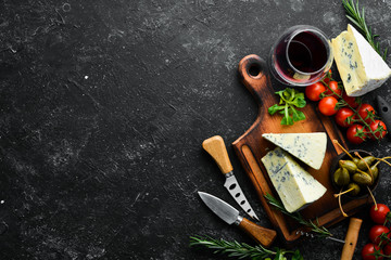 Blue cheese with mold on old table with spices. Top view. Free space for your text.