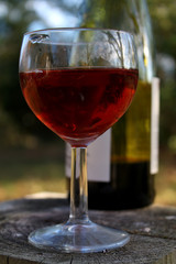 Rotweinglas mit Weinflasche im Hintergrund