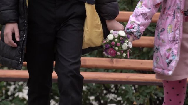 ittle cute boy giving to beautiful girl bouquet flowers peonies outdoors at sunset. first love, friendship, childhood, Funny kids, child. lovely childrens couple in nature, summer, slow-motion