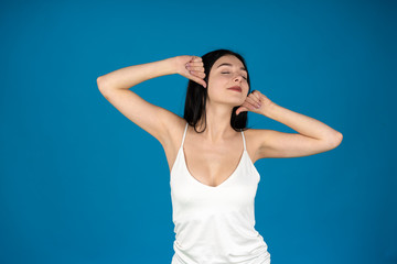 Fototapeta na wymiar Relaxed girl posing with closed eyes isolated on blue background