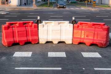 White and red plastic road safety barriers on the new highway street reconstruction and...