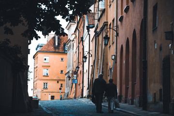 An old couple walking down the alley in old town of Warsaw in 07/20/2019