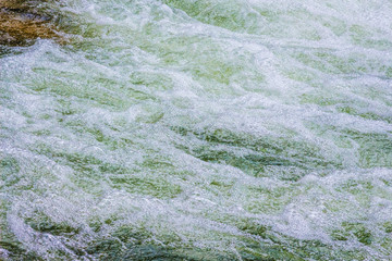 Fast flow in mountain river, texture of water_