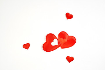 A couple of red hearts and many small red and white hearts on a white background.