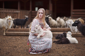 girl in the arms of a lamb farm in the mountains