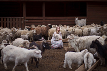girl in the arms of a lamb farm in the mountains