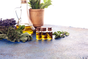 Fresh herbs from the garden and the different types of oils for massage and aromatherapy on table with lavender