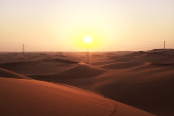 Fototapeta na wymiar Desert sunrise with power transmission towers and lines for solar energy concept. Riyadh, Saudi Arabiar 
