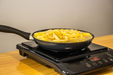 Frying chips on a black pan