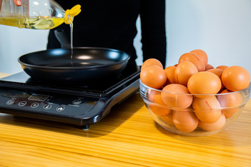Pouring oil on the black pan.