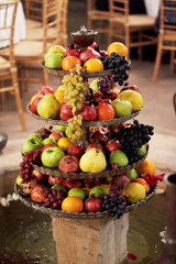 Fruit tray with apples, grapes, pomegranate, oranges, pear.