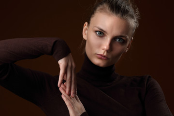 Beautiful girl in a maroon turtleneck on a brown background