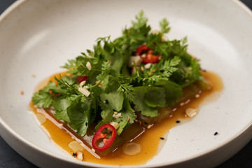 Smashed cucumbers plate with red chili pepper garlic parsley and vegetable oil.