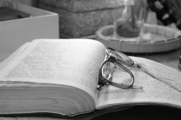 glasses and book on wooden table