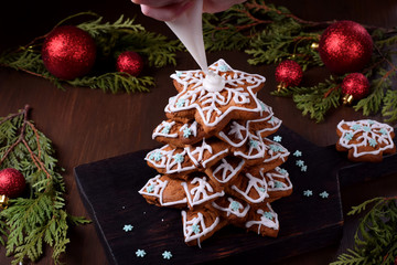 Fototapeta na wymiar Glazing the gingerbread Christmas tree. Festive decorations around
