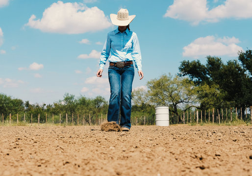 Cowgirl in outdoor arena during summer.