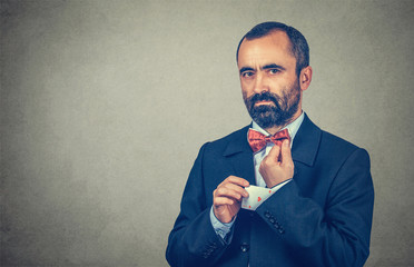 man pulling out a hidden ace card from suit jacket sleeve