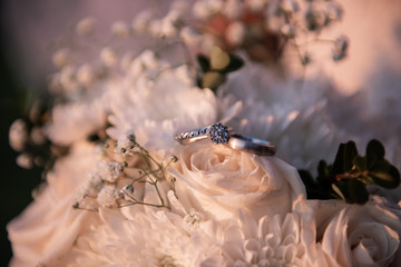 bunch of flowers with wedding rings