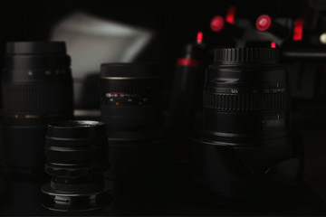 Plakat lenses and other equipment on a dark background, suitable for the photographer’s website header