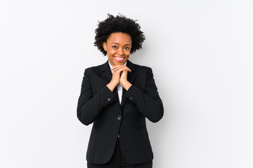 Fototapeta na wymiar Middle aged african american business woman against a white background isolated keeps hands under chin, is looking happily aside.