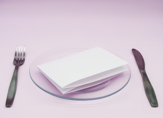 A note on a transparent plate with Cutlery on a pink background.  An empty list on a transparent plate. Mockup.        