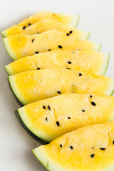 cut a slices of ripe yellow melon on a white background