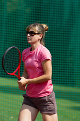 Female tennis player with racket on court