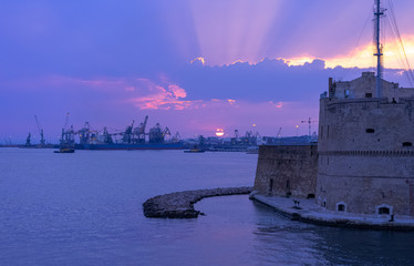 Taranto ancient castle on waterfront in mediterranean sea.  Amazing sunset on city landscape. Italy panorama