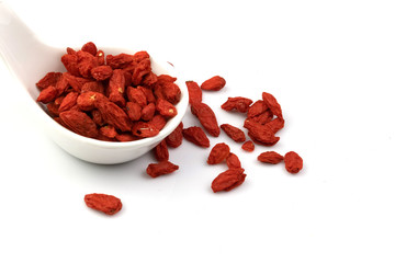 Dried goji berries in a spoon, isolated on a white background, herbs, vitamins, nourish the eyes.