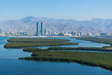 Aerial view of Ras al Khaimah, United Arab Emirates north of Dubai, looking at the city, Hajar mountains - Jebal Jais - and the Mangroves along the Corniche.