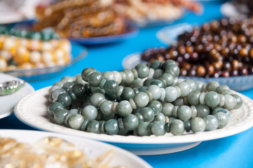Close up Jade rosary on  the white plate for sale.