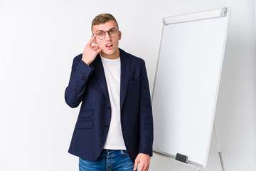 Young coaching man showing a white board showing a disappointment gesture with forefinger.