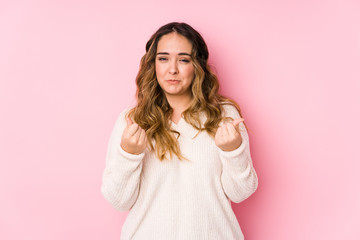 Fototapeta premium Young curvy woman posing in a pink background isolated showing that she has no money.
