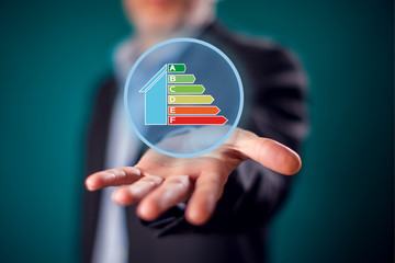 Businessman in suit showing open palm with virtual sign of energy rating. Energy saving and environment ptotection concept