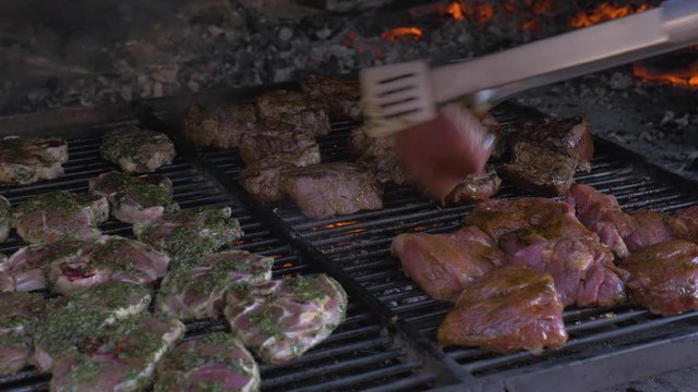 Tongs Turning Over Meat on Outdoor Grill
