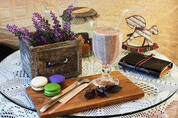 Blueberry smoothie or black currant purple milkshake and basil in the interior of the cafe