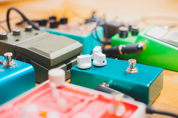 Guitar pedalboard on the floor of a recording studio. Generic guitar effects on the wooden floor....