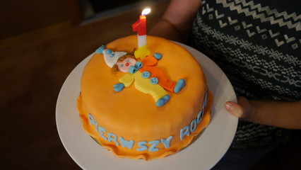 Tort urodzinowy z napisem w języku polskim pierwsze urodziny i świeczką jeden roczek - obrazy, fototapety, plakaty