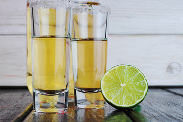 Two shots tequila with lime and salt on wooden table.Studio photography