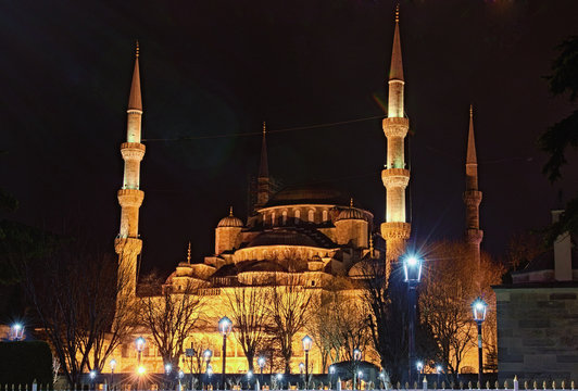 Night lights landscape of ancient Sultan Ahmed Mosque (Blue Mosque). It has five main domes, six minarets, and eight secondary domes. Beautiful street lanterns in foreground. Istanbul, Turkey